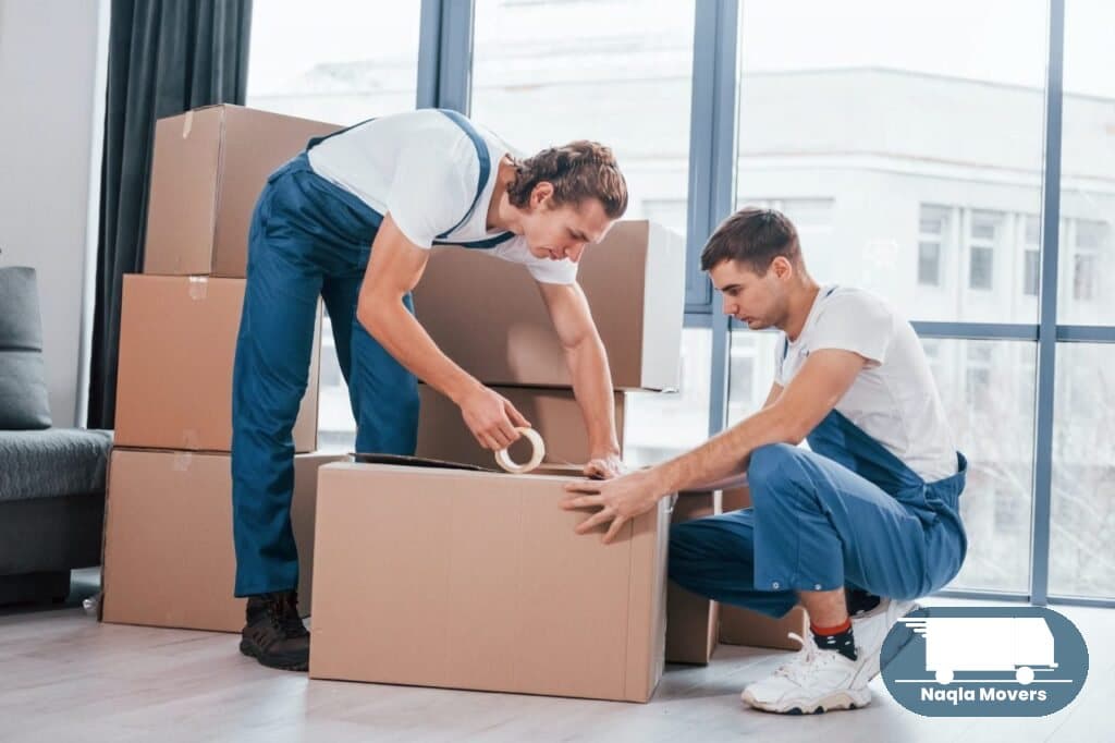 Naqla Movers packing team wrapping boxes indoors